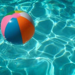 A beach ball floating around in a pool.